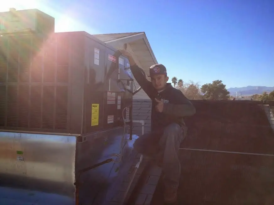 HVAC technician performing Air Duct Cleaning on a rooftop unit in Barnegat